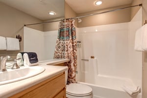 A shared bathroom offers a bathtub and shower combination.