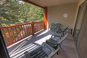 The private patio with 5 green chairs to take in the view of the evergreen trees.