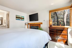 The main suite offers a kingsize bed, flatscreen TV and wooden furniture.
