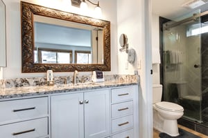 The en suite bathroom has a single sink vanity, granite countertops, and a separate water closet.