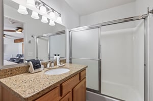 The shared bathroom has a single sink vanity and a bathtub and shower combination.