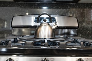 The kitchen has a stainless steel ovenrange and teapot.