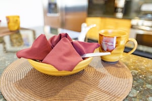 The breakfast bar with a place setting and colorful pottery for the dishes.