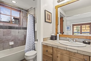 The en suite bathroom has a bathtub and shower combination and single sink vanity.