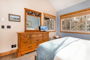 The main suite has a kingsize bed and wooden furniture.