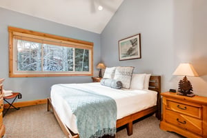 The main suite has a kingsize bed and wooden furniture.