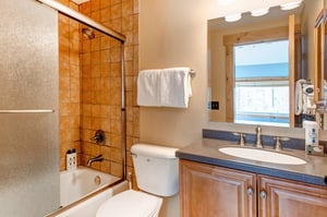 The en suite bathroom has a bathtub and shower combination.
