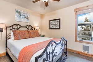 The second bedroom has a queensize bed with intricate metal frame.