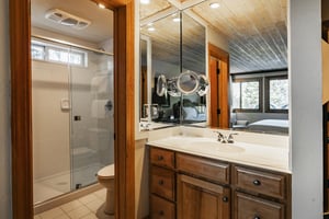 En suite main bathroom includes a vanity sink with white countertops and wood cabineets
