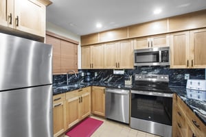 Snow Flower 007s kitchen has wood cabinets, granite countertops and stainless steel appliances.