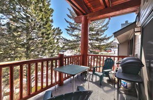 Private patio has green Adirondack chairs and a gas BBQ