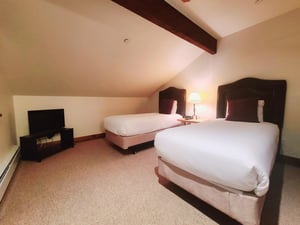 Fifth bedroom includes two comfortable twin sized beds with white linen and flat screen TV