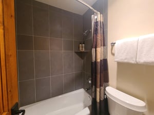 En suite fifth bathroom includes a bath and shower combination with gray tile surround