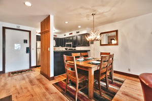 Dining room includes a beautiful antler chandelier with seating for 6