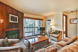 living room with southwestern style couch, two accent chairs, wooden coffee table and flat screen TV