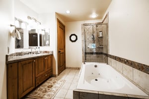 Full athroom with jetted tub and glass paneled shower