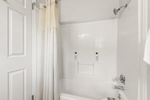 The en suite bathroom has a bathtub and shower combination.