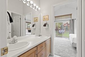 The en suite bathroom has a double sink vanity.