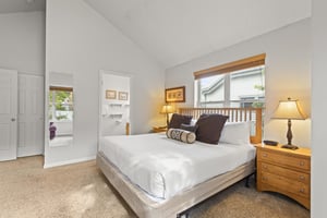 The bedroom has a king size bed with crisp white bedding and large throw pillows.