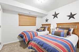 Two twin beds with blue and red accent blankets.