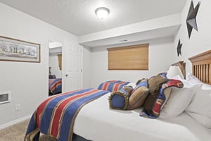 Two twin beds with blue and red accent blankets.