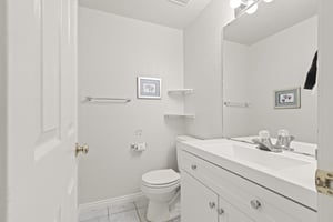 The bathroom in all white with a single sink vanity.