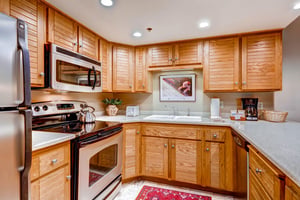 The wellequipped kitchen offers stainless steel appliances and wood cabinets.