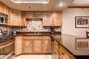 The wellequipped kitchen offers stainless steel appliances and wood cabinets.