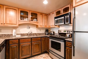 The wellequipped kitchen has wood cabinets and stainless steel appliances.
