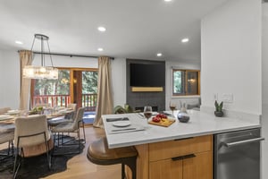 The open concept dining and living area with a breakfast bar with seating for 2.