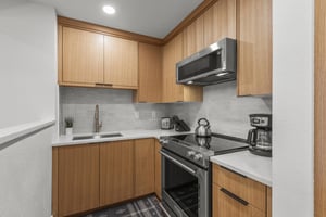 The kitchen with modern wood cabinetry and stainless steel appliances.