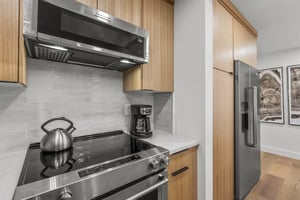 The kitchen with modern wood cabinetry and stainless steel appliances.