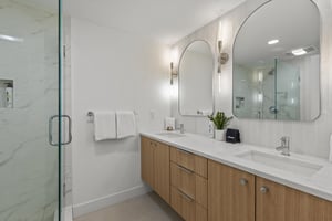 The en suite bathroom has double sink vanity, two mirrors and classic lighting.