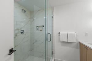 The walkin shower has a glass surround.