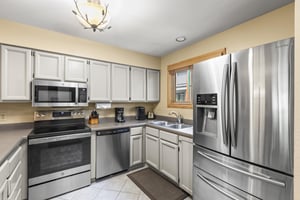 The wellequipped kitchen with grey cabinets and stainless steel appliances.