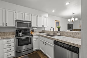 The wellequipped kitchen has stainless steel appliances and white cabinets.