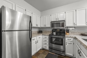 The wellequipped kitchen has stainless steel appliances and white cabinets.