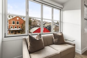 The love seat is perfectly situated in front of accordion windows to take in the mountain views.