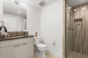 The en suite bathroom has a walk in shower and single sink vanity.