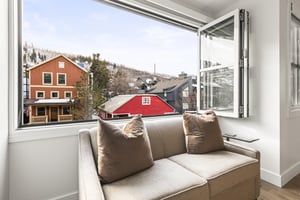 The love seat is perfectly situated in front of accordion windows to take in the mountain views.