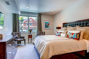The main suite offers a kingsize bed with cream bedding and colorful throw pillows.
