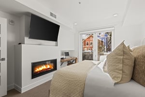 The main suite bedroom with a kingsize bed, gas fireplace, and flat screen TV.