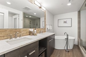 The en suite bathroom has a two sink vanity and a deep soaker tub.