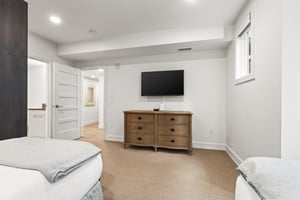 A second bedroom offers two twin beds, wooden dresser and flat screen TV.