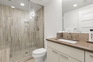 The en suite bathroom has a walk in shower and single sink vanity.