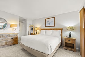 The main suite with a kingsize bed and wood headboard.