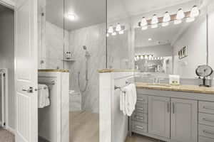 The en suite bathroom has a walkin shower and glass door.
