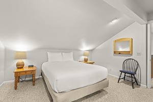 A queen bed with crisp white linens.