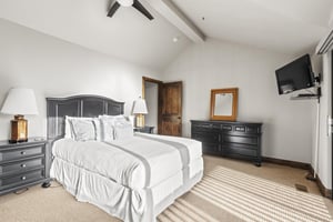 The main suite has a queensize bed, flatscreen TV, and wellappointed dark wood furnishings.