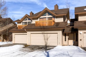 The cream colored exterior has private garage parking for two cars.